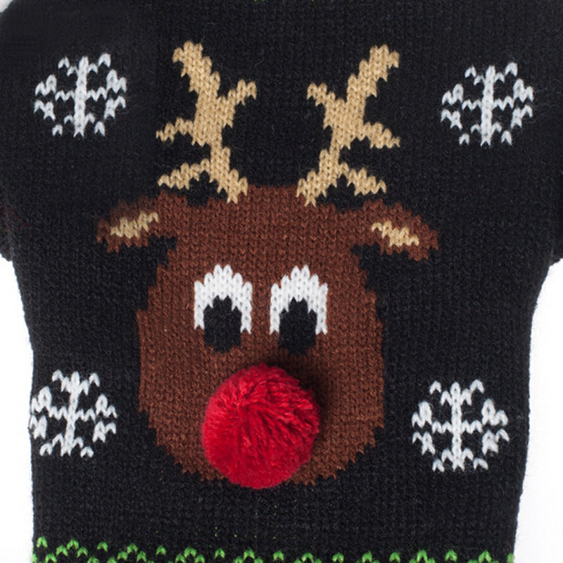 Close-up of a knitted Rudolph reindeer face with red pom-pom nose and snowflakes on a black Christmas pet sweater