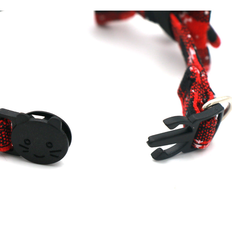 Close-up of the plastic buckle and strap on a red and black Christmas cat collar