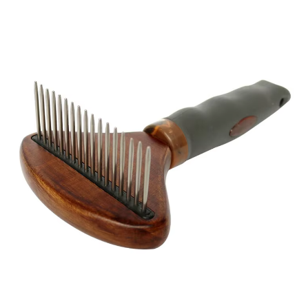Dog being groomed with deshedding dematting brush